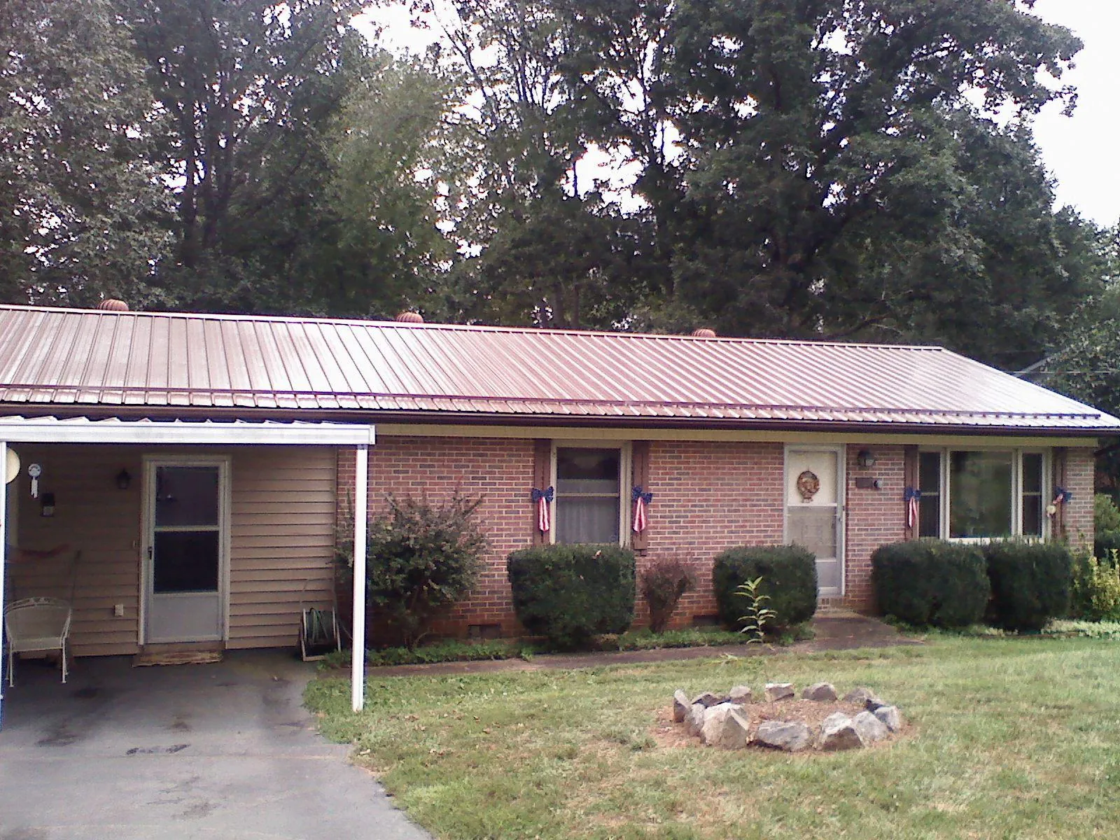 Bronze metal roof and carport on a brick ranch home — Roof Repair work by our crew in Russellville